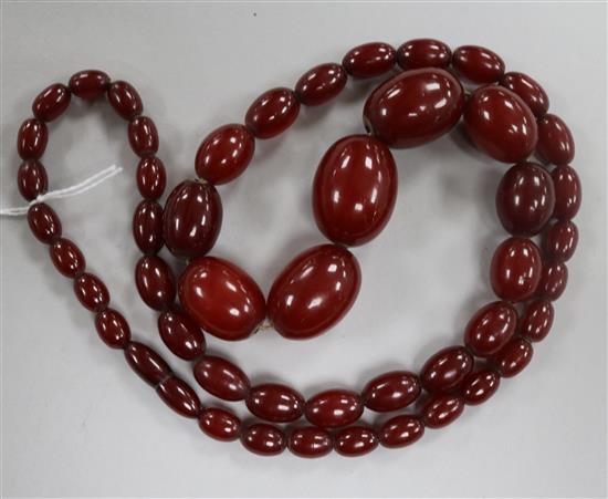 A single strand graduated simulated cherry amber oval bead necklace, gross weight 68 grams, 70cm.